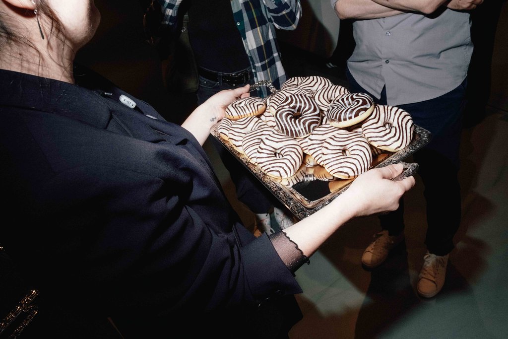 Eine junge Frau hält ein Tablett mit Donuts